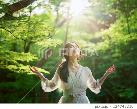 森の中で木漏れ日を浴びる美しい女性 124745210