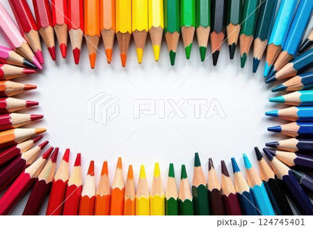 This image showcases a vibrant array of colored pencils arranged in a heart shape on a white background. The pencils are positioned with their tips pointing inward, creating a striking visual effect.  124745401