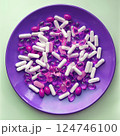 Pink medical pills and herb capsules on violet plate 124746100