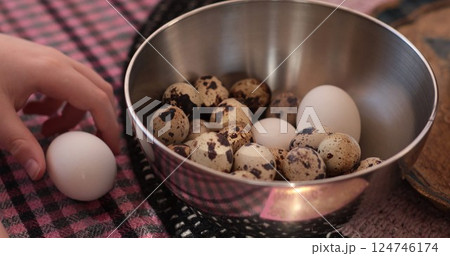 Boiled quail eggs prepared for cooking using fresh organic eggs with hand reaching for one available in a bowl Boiled quail eggs prepared for cooking using fresh organic eggs with hand reaching for one available in a bowl 124746174