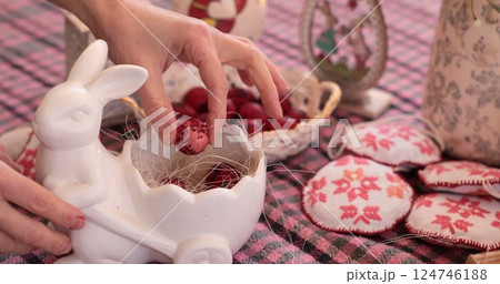 Coloring egg and decorating Easter eggs in ceramic display with red eggs for festive celebration 124746188