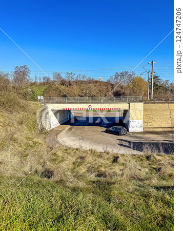 Country Road Car Passing Under Railway Bridge on Clear Sunny Blue Sky Day. High quality photo 124747206