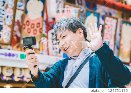 大阪の新世界で動画を撮る中年男性 124751126