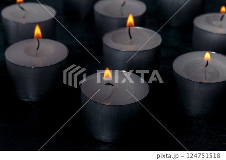 Tea light candles on a dark background, many lights in the dark 124751518