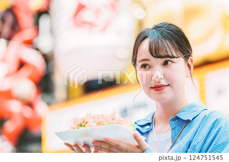 大阪道頓堀で名物のたこ焼きを食べる女性 124751545