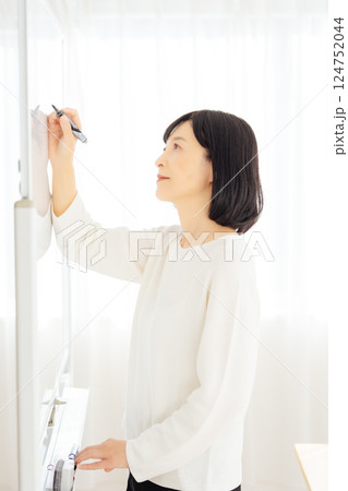 休日に急遽打合せをするミドルキャリアウーマン 124752044