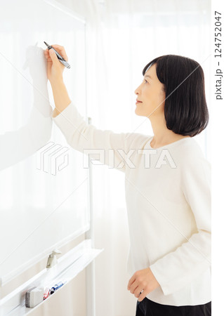 休日に急遽打合せをするミドルキャリアウーマン 124752047