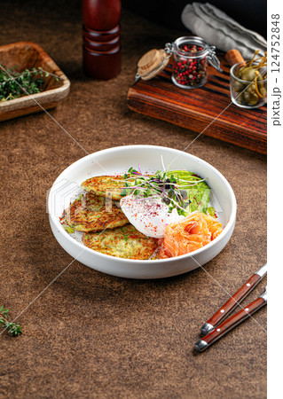 Breakfast with poached eggs zucchini pancakes Breakfast with poached eggs zucchini pancakes 124752848