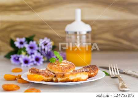 Ruddy cheese pancakes with honey and mint in a white plate Ruddy cheese pancakes with honey and mint in a white plate 124752872