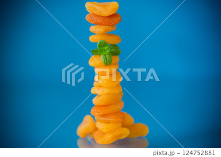 Aesthetic composition with dried apricots and fresh mint on a blue background Aesthetic composition with dried apricots and fresh mint on a blue background 124752881