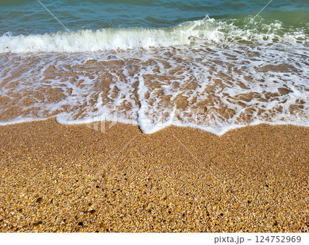The concept of recreation. Beautiful azure sea with white foam and a beach on a clear sunny day 124752969