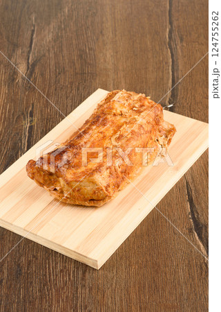 Baked pork meat on a wooden cutting board. Baked pork meat on a wooden cutting board. 124755262