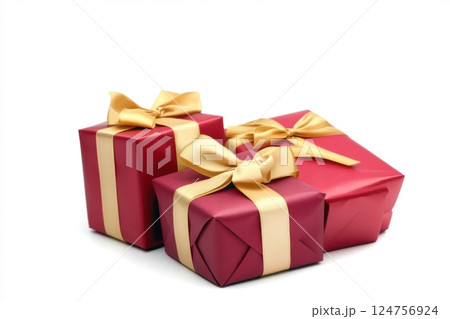 elegant holiday gift set with three beautifully wrapped presents in red and gold, adorned with luxurious ribbons and carefully tied bows, rich textured paper, festive celebration mood 124756924