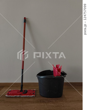 Mop, bucket and wringer resting on wooden floor for spring cleaning 124757099