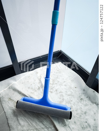 Cleaning windows with a blue squeegee during spring cleaning 124757122