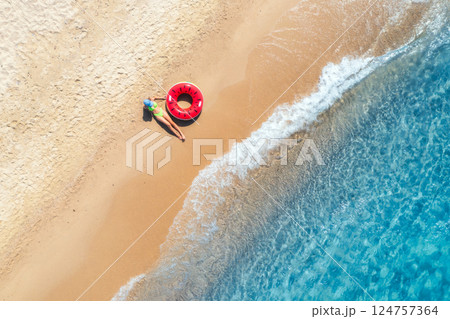 Aerial view of a woman with red swim ring on beach and sea 124757364