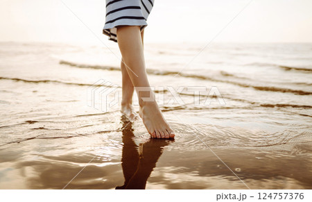 Woman leg close up walking on sand relaxing in beach at sunset. Sexy lean and tanned legs. Woman leg close up walking on sand relaxing in beach at sunset. Sexy lean and tanned legs. 124757376