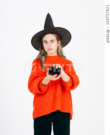 Portrait smiling girl in witch black hat, with pumpkin jack sweet candy. Isolated white background 124757821
