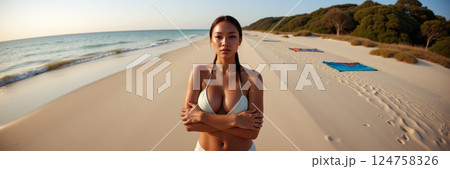 A woman standing on a beach. 124758326