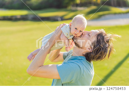 Father and newborn baby on a meadow in the park. Tender moment of bonding and love in nature. Parenthood, fatherhood, and family connection concept 124758453
