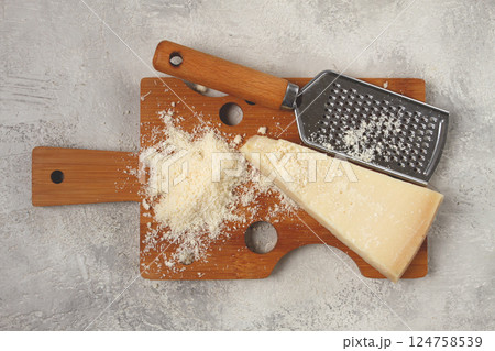 Freshly sliced and grated cheese, parmesan cheese, on a wooden chopping board, rustic style, no people Freshly sliced and grated cheese, parmesan cheese, on a wooden chopping board, rustic style, no people 124758539