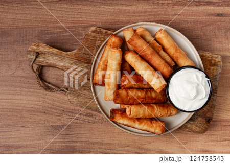 fried spring rolls with cheese, on a wooden background, with cream sauce, no people, fried spring rolls with cheese, on a wooden background, with cream sauce, no people, 124758543