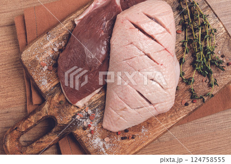 Fresh raw duck breasts, on a wooden chopping board, with herbs and spices, no people Fresh raw duck breasts, on a wooden chopping board, with herbs and spices, no people 124758555