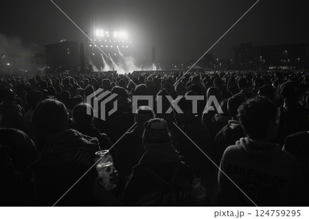 A vast audience gathers under bright stage lights at night, enjoying a live performance in a bustling city atmosphere A vast audience gathers under bright stage lights at night, enjoying a live performance in a bustling city atmosphere 124759295
