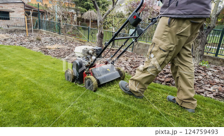 Man trimming grass with trimmer on lawn. Lawn mowing. Spring gardening 124759493