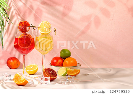 Flyer with glasses of various alcoholic drinks and tropical fruits. Two royal cocktails of blood orange and lemon, ice cubes, rum and tequila. Concept of a summer party and relaxation in a restaurant. 124759539