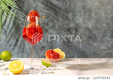 Banner with glasses of alcoholic drinks and tropical fruits. Royal cocktail of blood orange, ice cubes, rum and tequila. Concept of summer party and rest in a restaurant. Menu for a bar or cafe Banner with glasses of alcoholic drinks and tropical fruits. Royal cocktail of blood orange, ice cubes, rum and tequila. Concept of summer party and rest in a restaurant. Menu for a bar or cafe 124759543