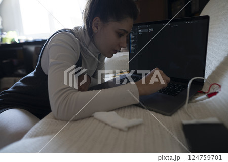Focused Workflow A Student is Engaged in Coding with a Laptop and Concentrating Hard 124759701
