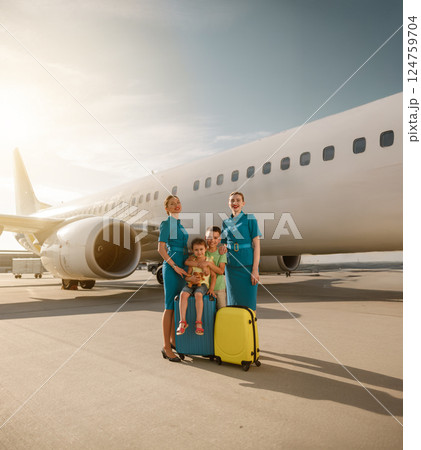 A Happy Family with Flight Attendants Nearby an Airplane at the Airport with joy and excitement 124759704