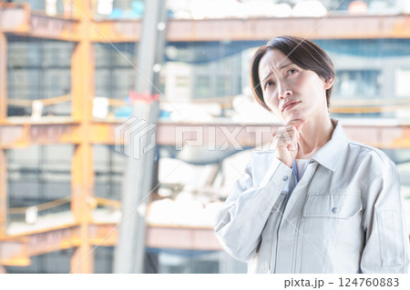 建設現場で困った表情をする女性作業員 建設現場で困った表情をする女性作業員 124760883