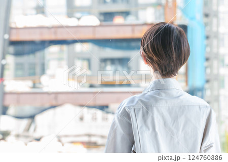 建築現場を確認する女性作業員の背中 建築現場を確認する女性作業員の背中 124760886