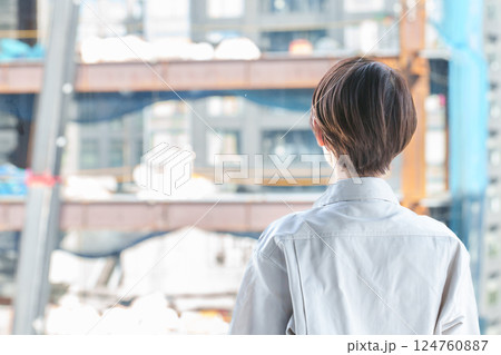 建築現場を確認する女性作業員の背中 124760887