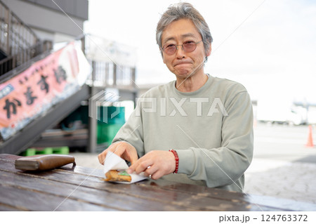 ベンチで食事するシニア男性 ベンチで食事するシニア男性 124763372