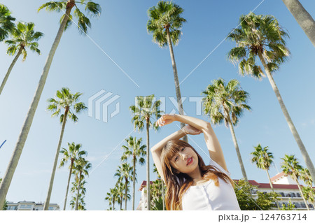ヤシの木をバックにリゾートを楽しむ女性 124763714