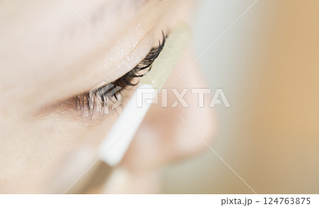 Close-Up of a Woman Applying Eyeliner to Their Eyelid 124763875