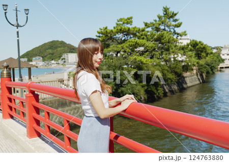 赤い橋の欄干に立つ女性 124763880