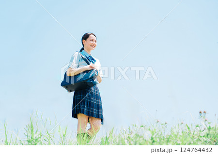 河川敷を歩く夏服の女子高生 河川敷を歩く夏服の女子高生 124764432