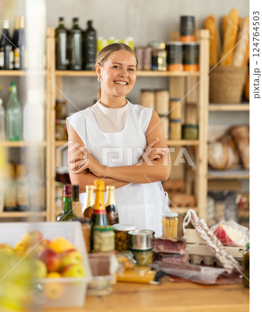 Young woman with a set of products on the background of shelves with food in a store Young woman with a set of products on the background of shelves with food in a store 124764503