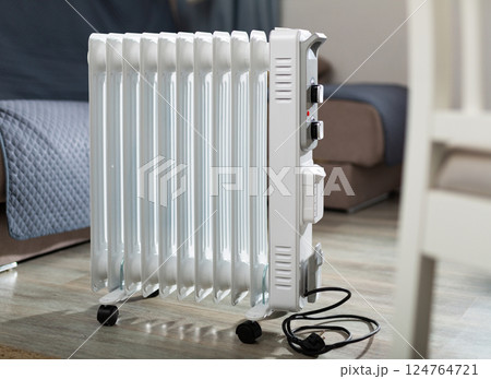 Electric oil heater on floor in room Electric oil heater on floor in room 124764721