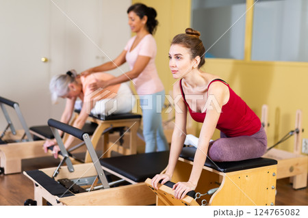 Young woman doing exercises on wunda chair in pilates studio 124765082