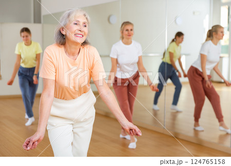 Ordinary females exercising dance moves in dance center 124765158