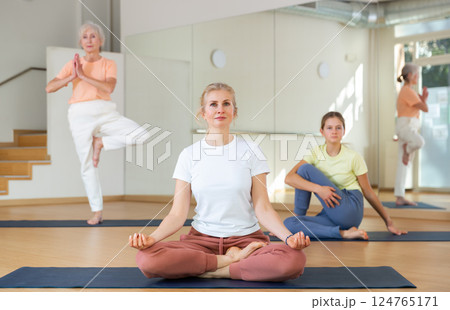 Continuity of generations - family in lotus position doing yoga in gym 124765171