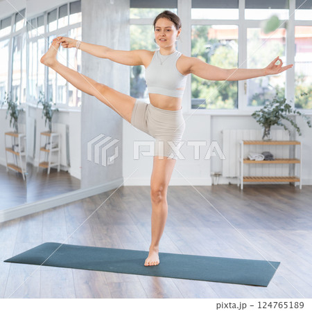 Lover of active lifestyle on yoga mat perform doing Utthita Hasta Padangushthasana in gym Lover of active lifestyle on yoga mat perform doing Utthita Hasta Padangushthasana in gym 124765189