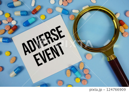 Adverse Event text on sticky note paper with Medicine and Magnifying glass on blue background 124766909