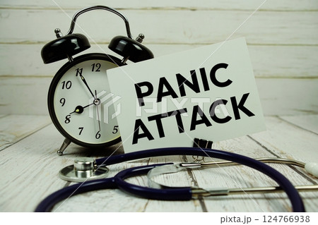 Panic Attacks text on paper card with alarm clock and stethoscope on wooden background 124766938