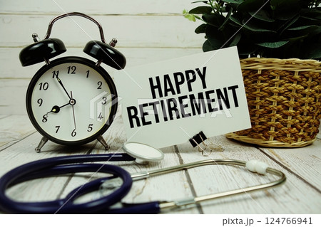 Happy Retirement text on paper card with alarm clock and stethoscope on wooden background 124766941